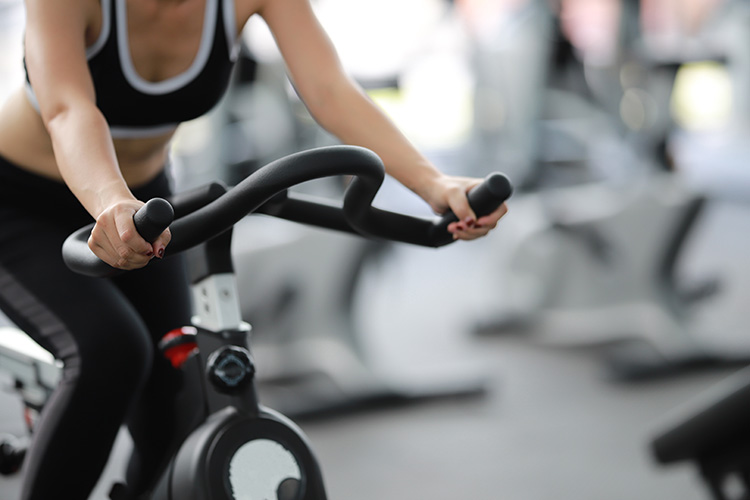 Femme sportive sur un vélo dans une salle de sports 